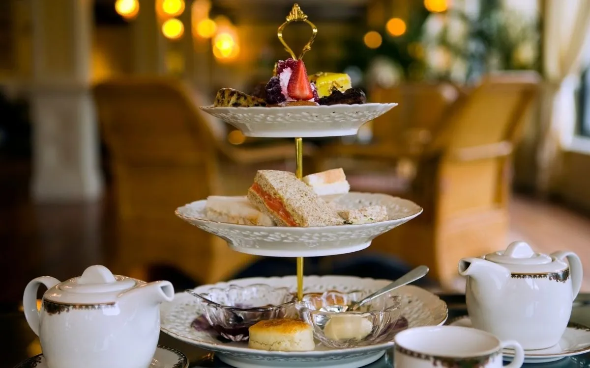 Het interieur van een theesalon in Londen of York, met gedekte tafels en personeel in de verte, zonder herkenbare gasten.