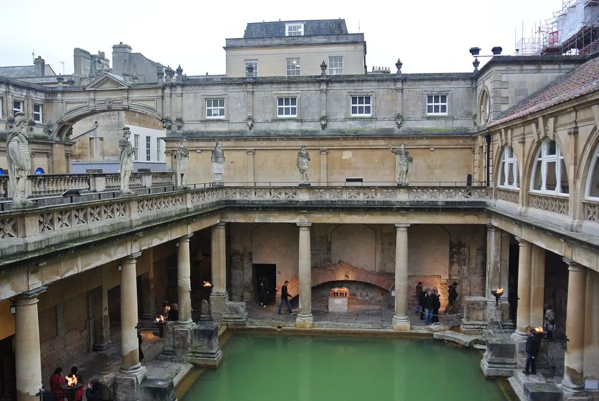 Het Great Bath in de Roman Baths, met het groene water en de zuilengalerij eromheen.