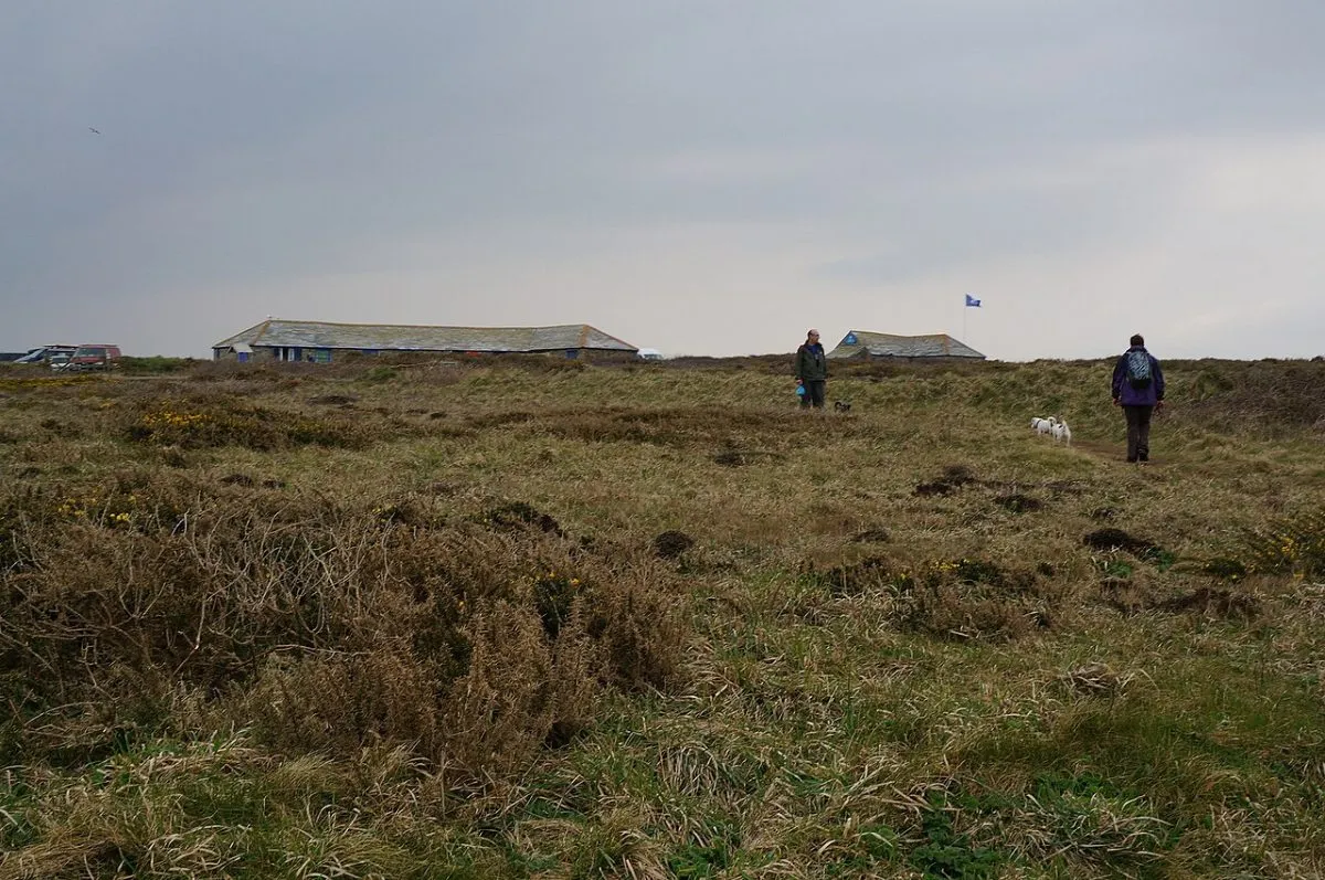 De parkeerplaats en het pad naar het uitkijkpunt bij Carnewas, met het gebouwtje van de National Trust erbij. Praktisch beeld, geen landschapsfoto.