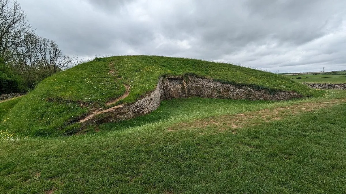 Belas Knap, de grafheuvel boven Winchcombe, met de valse ingang van steen goed in beeld en het grasland eromheen.