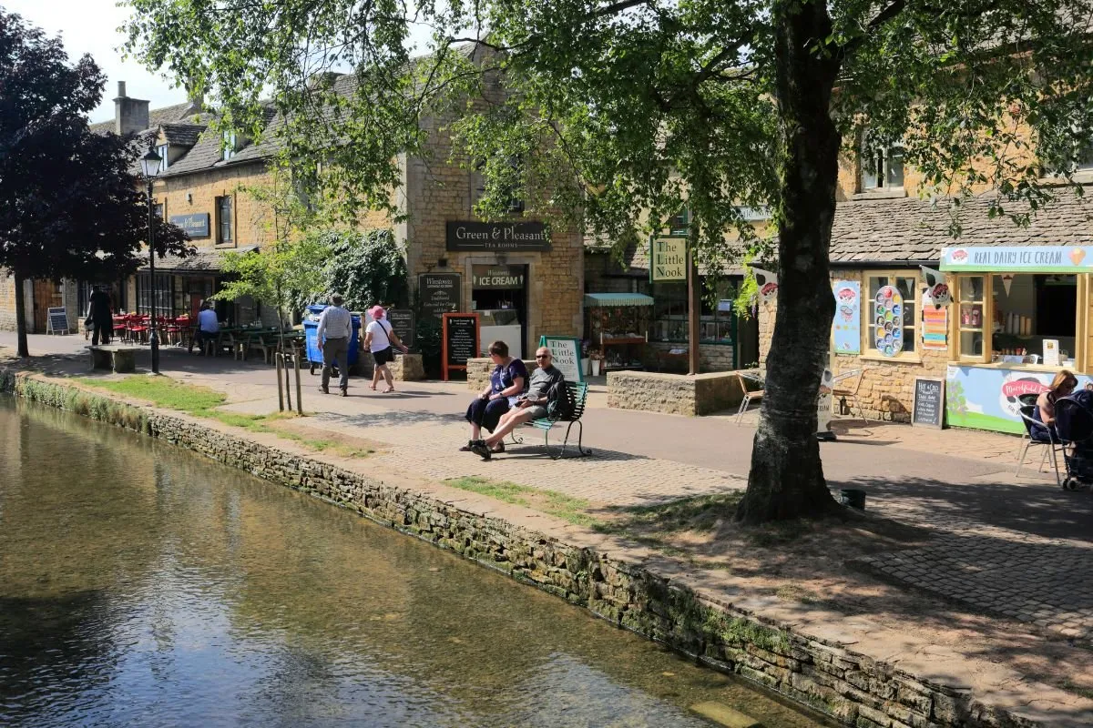 De lage stenen bruggetjes over de Windrush in Bourton-on-the-Water, met de groene bermen aan weerszijden.