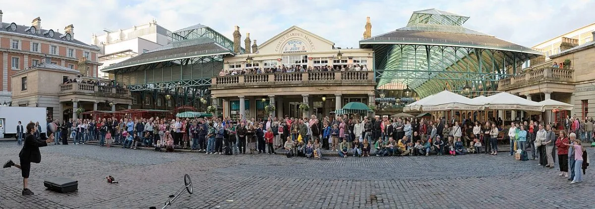Een straatartiest midden op de piazza met publiek in een kring eromheen. Het gaat om het publiek en de ruimte, niet om een portret van de artiest.