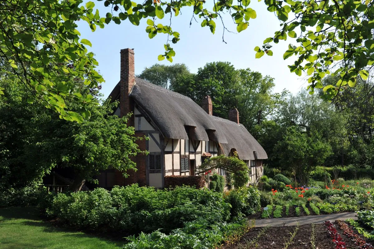 Anne Hathaway's Cottage met het rieten dak en de tuin ervoor, over de volle breedte. Dit is het beeld dat mensen van Stratford verwachten.