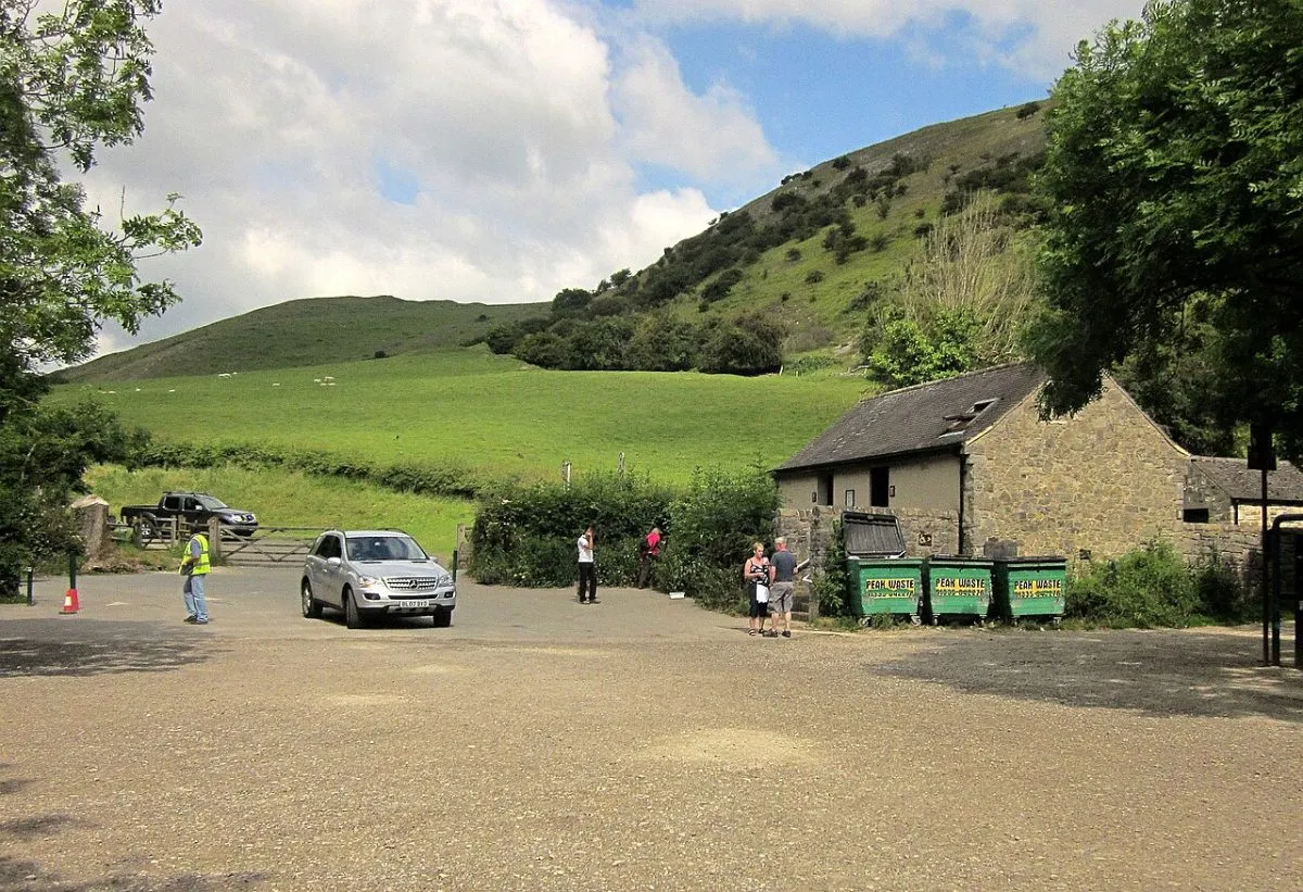 De parkeerplaats van Dovedale met het toiletgebouw en de welkomstwagen van het National Trust, van de kant gefotografeerd.