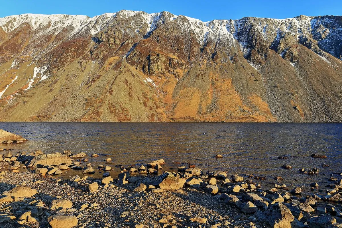 Wast Water met de screes, de steile puinhellingen die recht in het water aflopen, en de bergen erachter. Bij stil weer met de spiegeling in het meer.