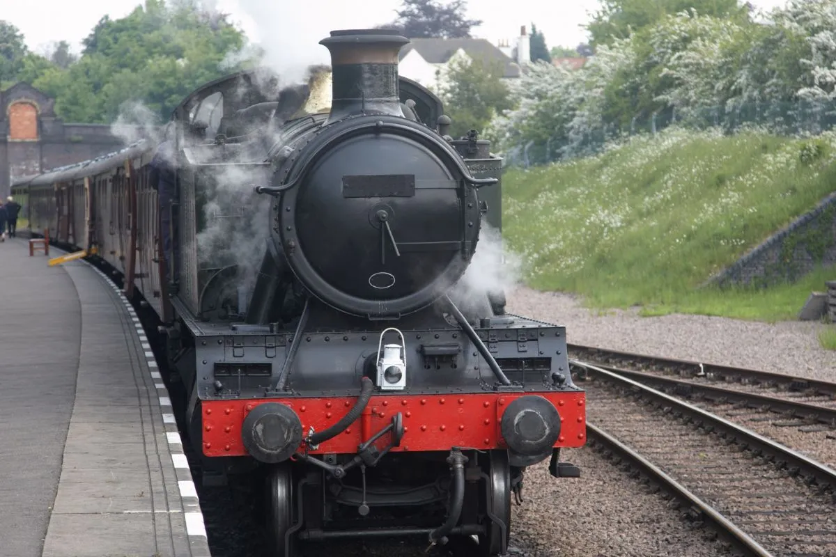 Het Ribblehead Viaduct met een trein erop, van een afstand zodat alle 24 bogen en het lege landschap eromheen te zien zijn.