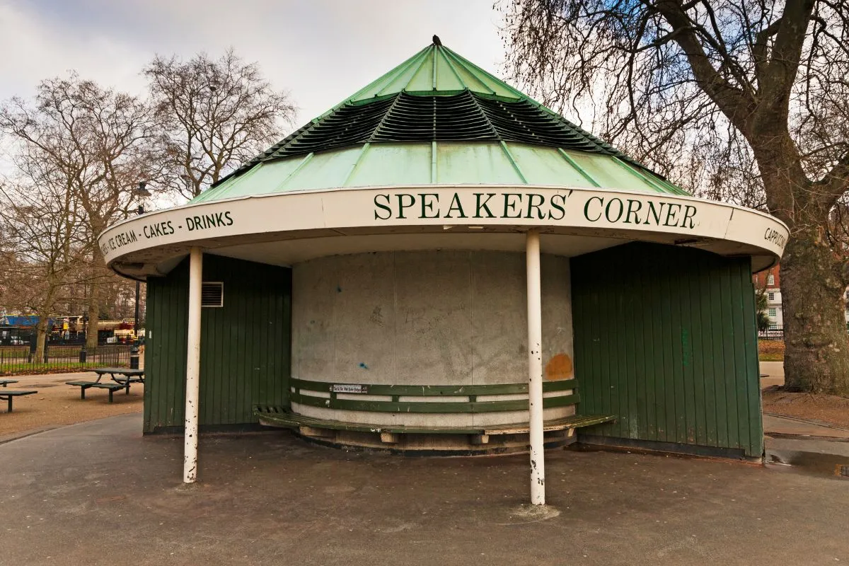 Speakers' Corner op een zondagochtend, met een spreker en een kring luisteraars. Gezichten hoeven niet herkenbaar te zijn.