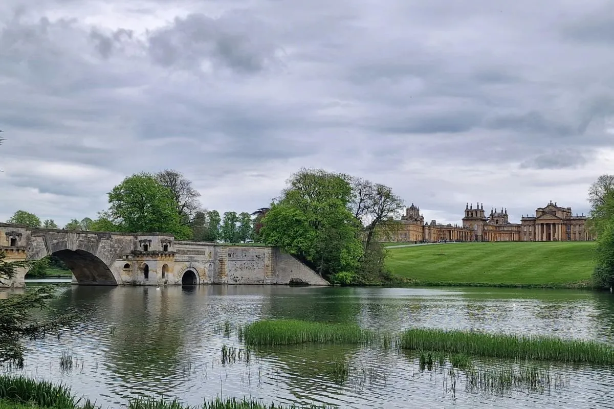 Blenheim Palace vanaf de brug over het meer gezien, met de voorgevel en het park.