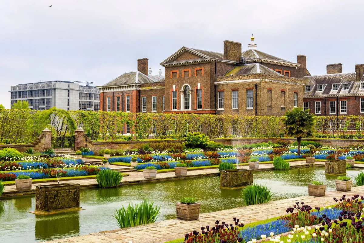 Het pad door Kensington Gardens richting het paleis, met een van de toegangshekken van het park.