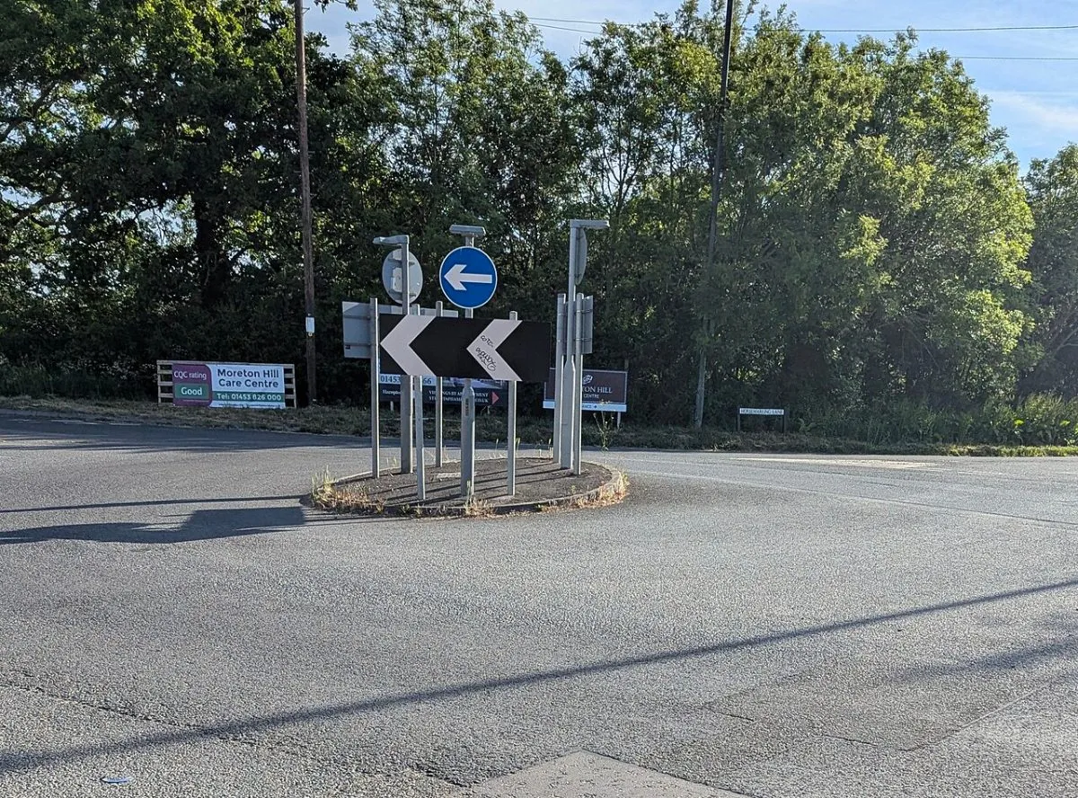 Een auto die van een parkeerplaats of een tankstation de weg op draait in Engeland. Het moment van invoegen is wat de foto moet laten zien, niet de auto zelf.