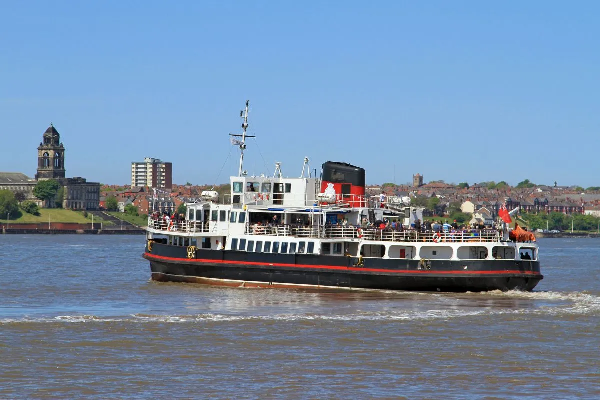 De Mersey Ferry op de rivier, met de oever van de Wirral erachter