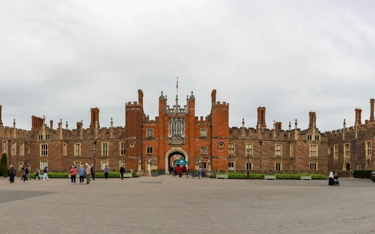 De Tudor-gevel van Hampton Court Palace met de schoorstenen en de poort in het midden.