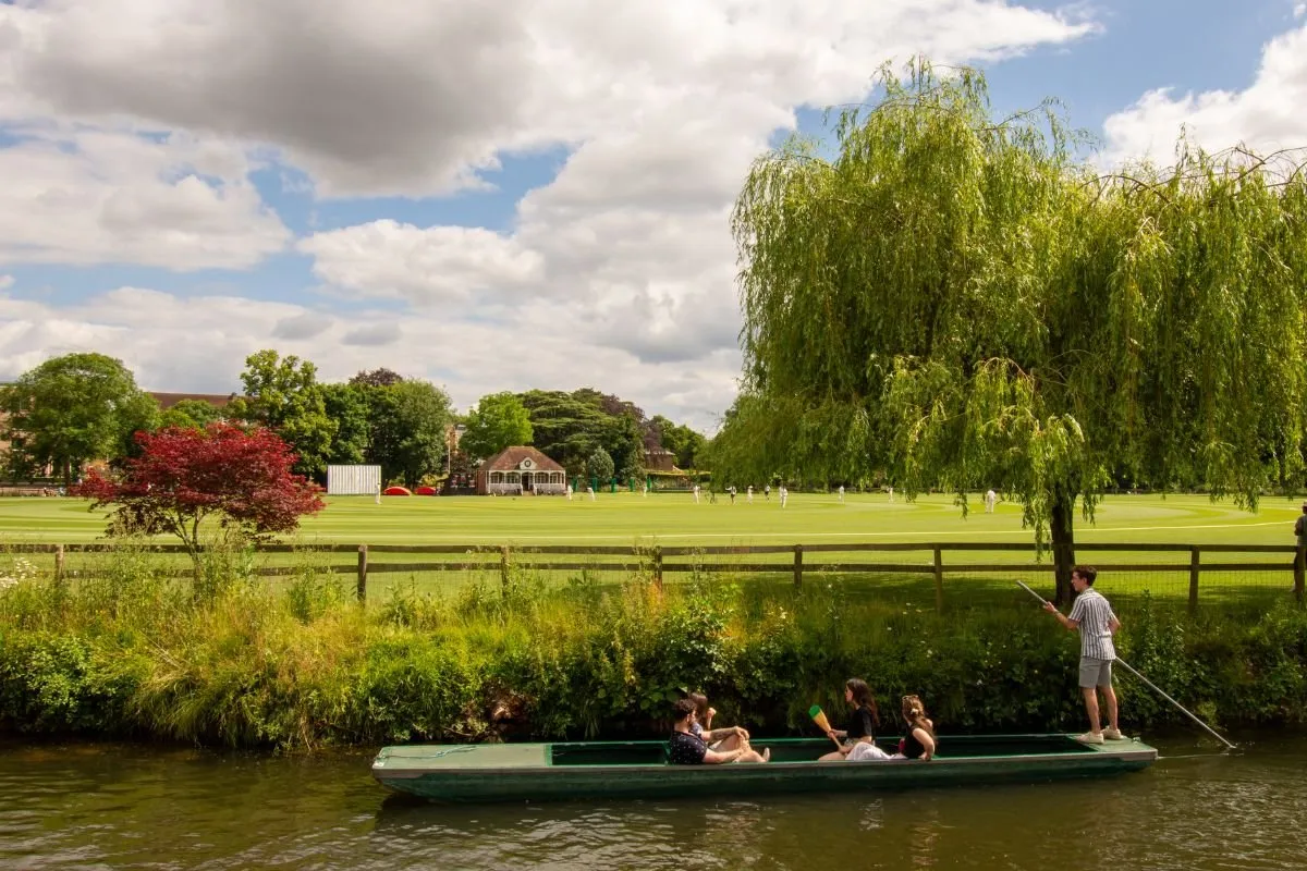 Punters op de Cam achter King's College, met de kapel en de gazons aan de waterkant.