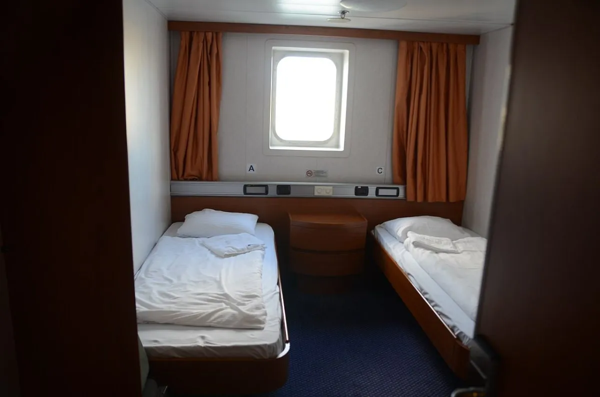 Een buitenhut met zeezicht op het DFDS-schip, met het bed en het raam op zee.