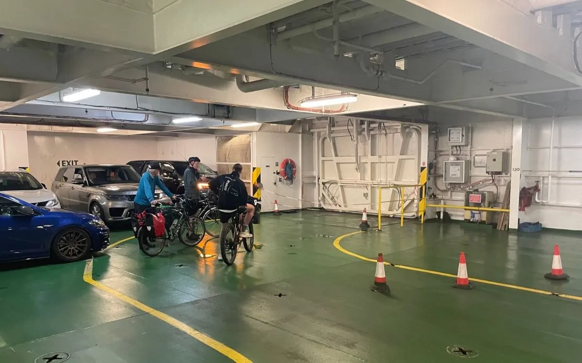 De transferbus van P&O bij de terminal, met wachtende voetpassagiers en hun bagage.