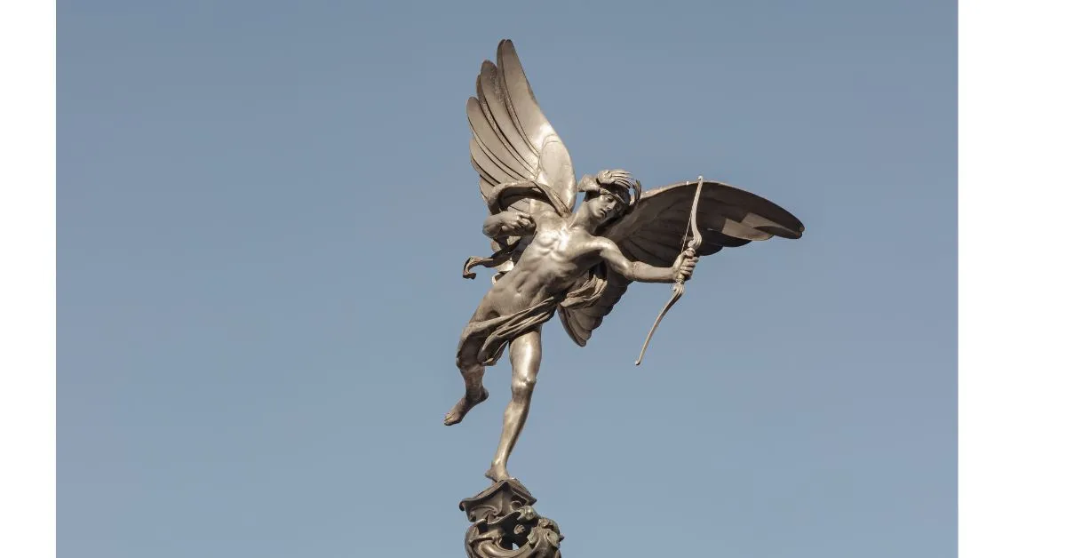 De fontein met het gevleugelde beeld van dichtbij, zodat de boog en de houding zichtbaar zijn. Liefst overdag, want in het donker verdwijnt het tegen het scherm.