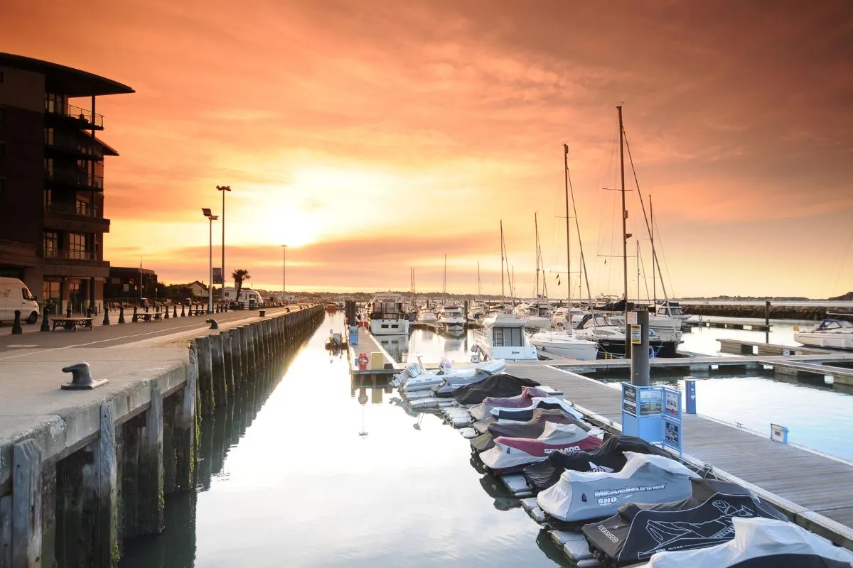 Poole Quay bij zonsondergang, met de jachthaven en de boten langs de steiger