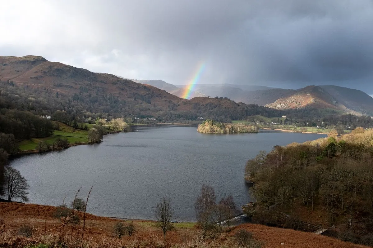 Grasmere of Ambleside vanaf de weg, met stenen huizen en de heuvels erachter. Een dorpsbeeld dat laat zien hoe compact deze plaatsen zijn.