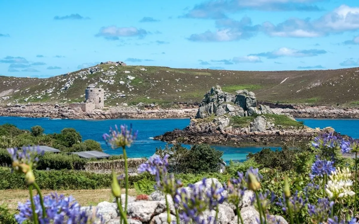 De Scillonian III die de haven van Penzance uitvaart, met de kade en de stad erachter.
