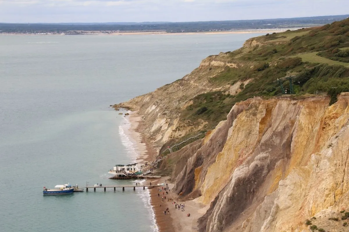 De stoeltjeslift boven de kliffen van Alum Bay, met de gekleurde zandlagen in de klif en het strand beneden.