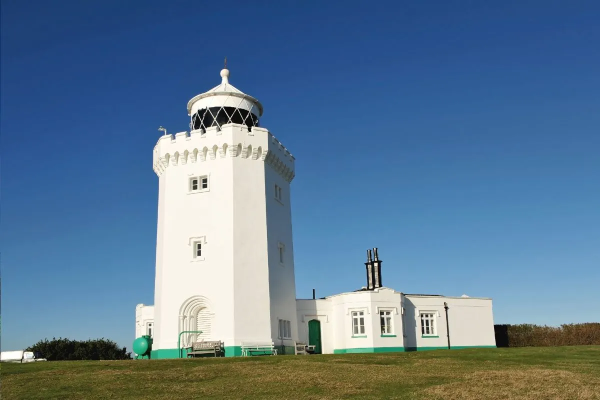 De witte vuurtoren van Southwold tussen de huizen van het dorp, van dichtbij zodat de ongewone plek te zien is.