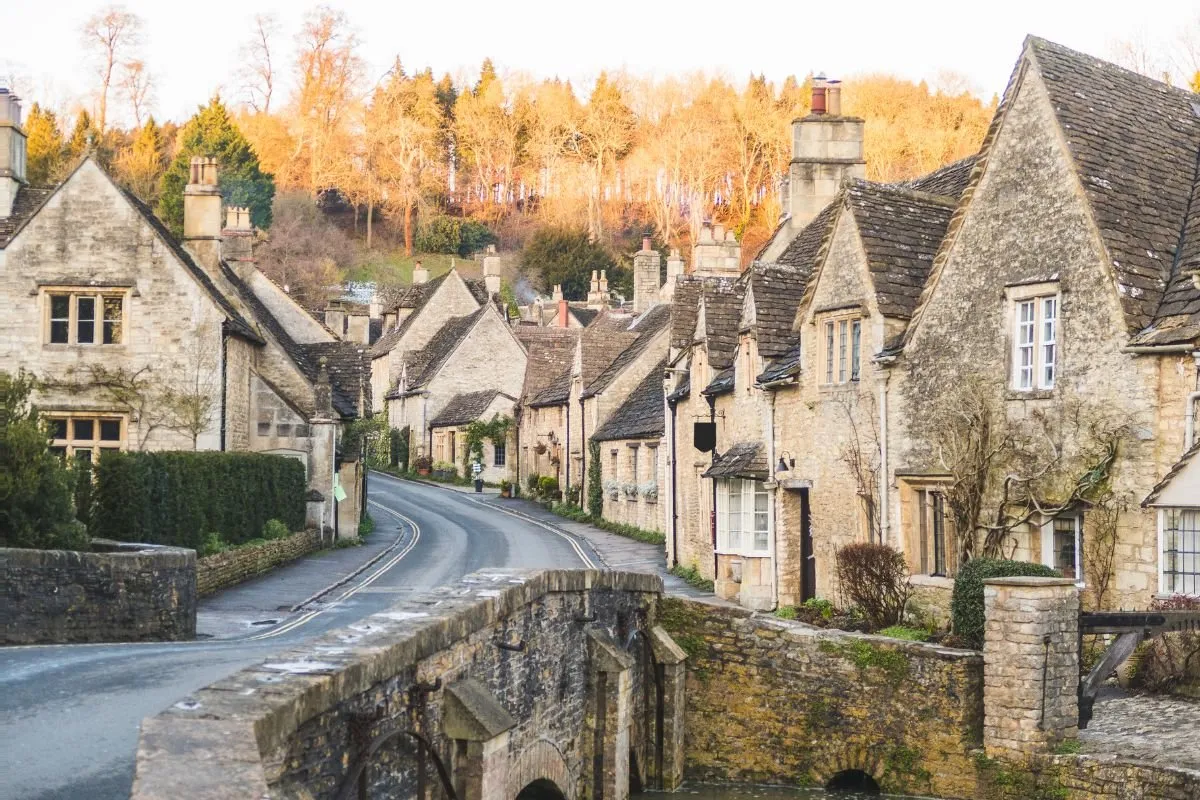 De brug over de By Brook in Castle Combe, met de honingkleurige huizen erachter.