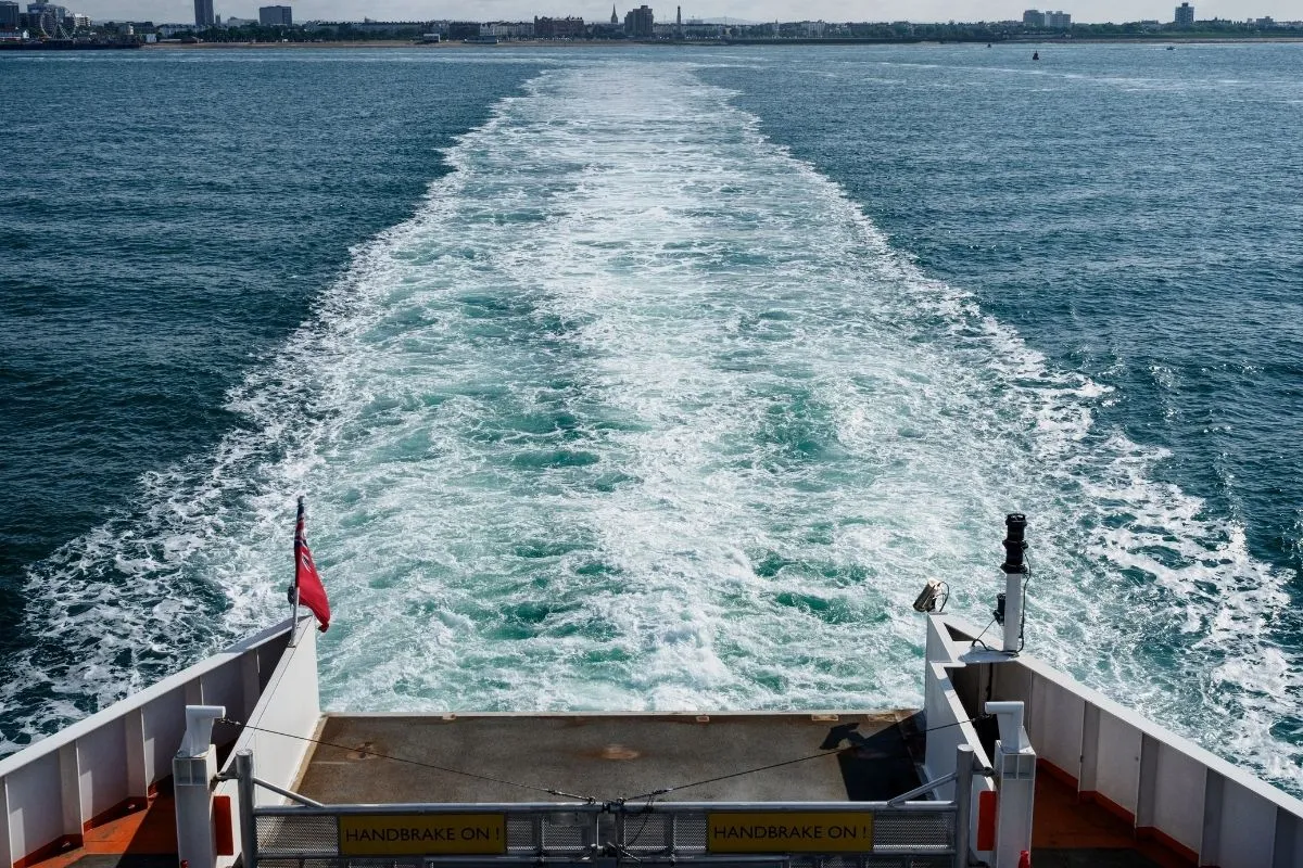 Een veerboot onderweg naar het Isle of Wight over de Solent, met het eiland aan de horizon.